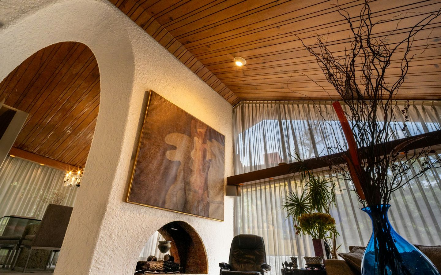 Living room with a plastered arch, timber ceiling and tall windows