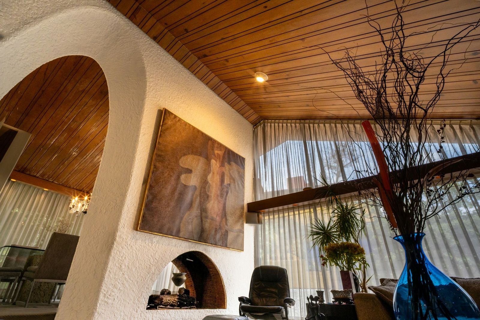 Living room with a plastered arch, timber ceiling and tall windows